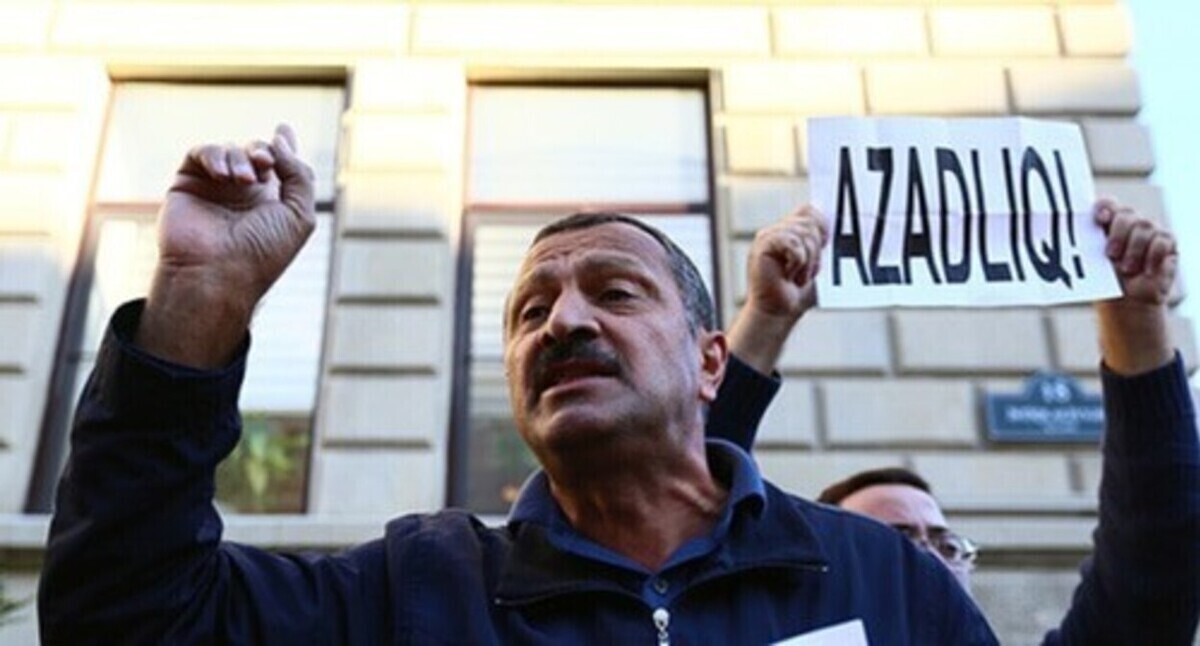 Tofig Yagublu at the background of a poster saying "Freedom!". Photo by Aziz Karimov for the "Caucasian Knot"