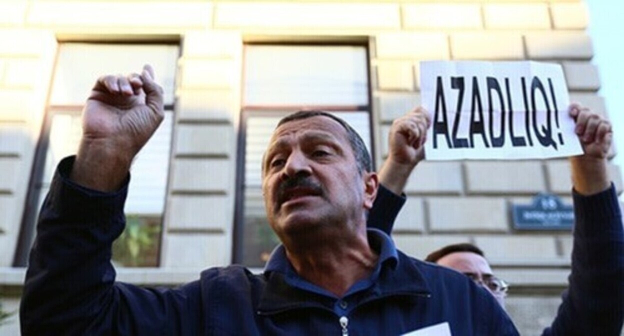 Tofig Yagublu at the background of a poster saying "Freedom!". Photo by Aziz Karimov for the "Caucasian Knot"